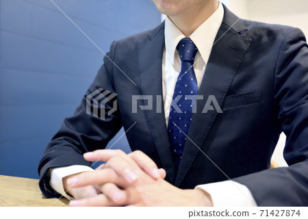Person in charge listening to customers with both hands on the table 71427874
