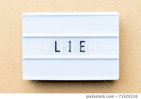 White lightbox with word lie on wood background White lightbox with word lie on wood background 71428126