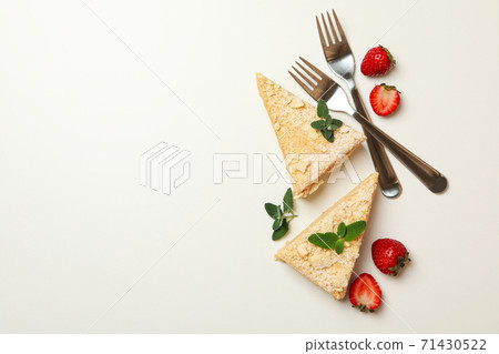 Pieces of Napoleon cake, strawberry and forks on white background 71430522