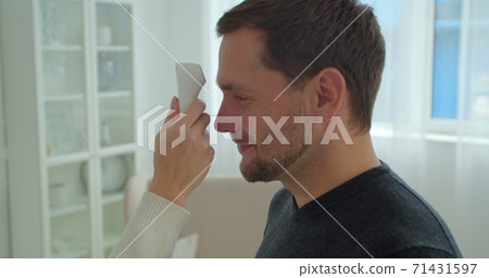 COVID-19 Body temperature measuring for coronavirus. A man's temperature is taken for controlling disease. COVID-19 Body temperature measuring for coronavirus. A man's temperature is taken for controlling disease. 71431597