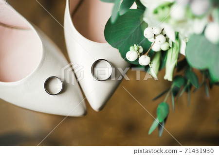 Beautiful toned picture with wedding rings and wedding shoes 71431930
