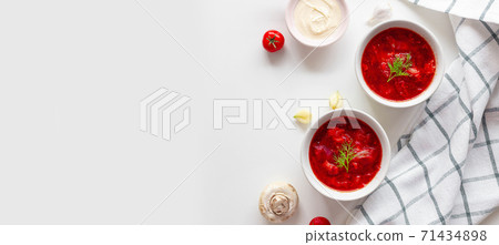 Traditional home Ukrainian beet soup with fresh green dill. Russian borscht in bowl of tomatoes, sour cream, and mushrooms on a white background with copy space. Traditional home Ukrainian beet soup with fresh green dill. Russian borscht in bowl of tomatoes, sour cream, and mushrooms on a white background with copy space. 71434898