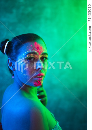 Portrait of woman in fluorescent paint in neon lighting. Portrait of woman in fluorescent paint in neon lighting. 71435010