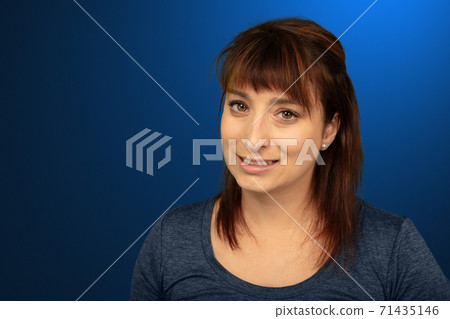 woman in her thirties smiling on commercial blue gradient background woman in her thirties smiling on commercial blue gradient background 71435146