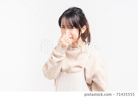 Young woman pinching her nose Young woman pinching her nose 71435555