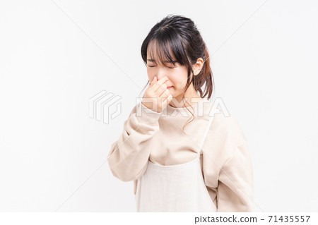 Young woman pinching her nose 71435557