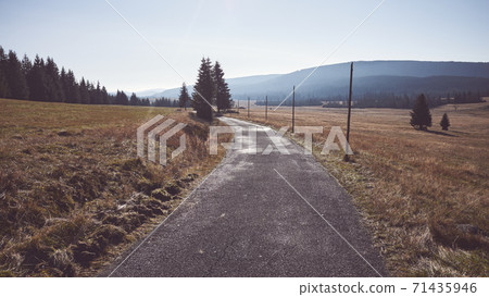 Mountain road against the sun, Jizera Mountains, Poland. Mountain road against the sun, Jizera Mountains, Poland. 71435946