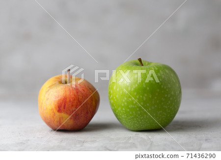 Two green and red apples on a gray concrete background 71436290