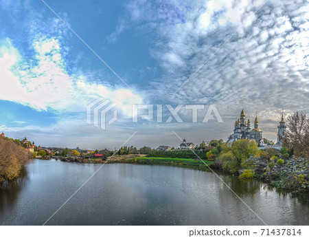 Panoramic view of the Rostavitsya river and the landscape park with the Orthodox Christian church of St. Eugene with cupoladomes and crosses in the village. Buky, Ukraine Panoramic view of the Rostavitsya river and the landscape park with the Orthodox Christian church of St. Eugene with cupoladomes and crosses in the village. Buky, Ukraine 71437814