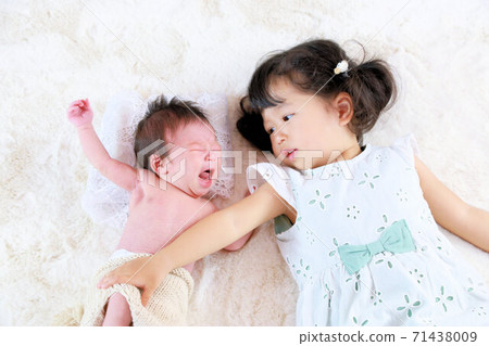 Birth of a new family, newborn photo of cute sisters of baby and older sister Birth of a new family, newborn photo of cute sisters of baby and older sister 71438009