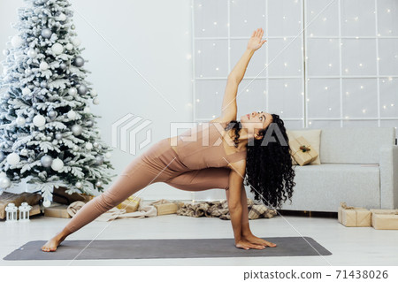 Beautiful young woman practices yoga asana Virabhadrasana at the yoga class. 71438026