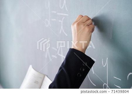 Japanese female teacher writing on the blackboard in the classroom 71439804