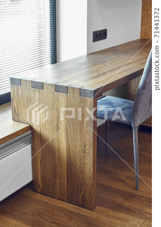 Modern furniture. Box joint solid wooden desk against the background of the window Modern furniture. Box joint solid wooden desk against the background of the window 71441372
