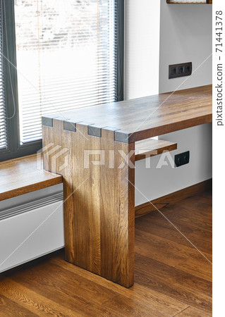 Modern furniture. Box joint solid wooden desk against the background of the window Modern furniture. Box joint solid wooden desk against the background of the window 71441378