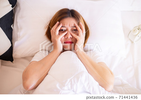 Nightmare or bad dream,Asian woman with fear and panic while lying down under the blanket in bedroom 71441436