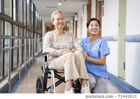 asian senior woman and her caregiver looking at camera smiling asian senior woman and her caregiver looking at camera smiling 71442613