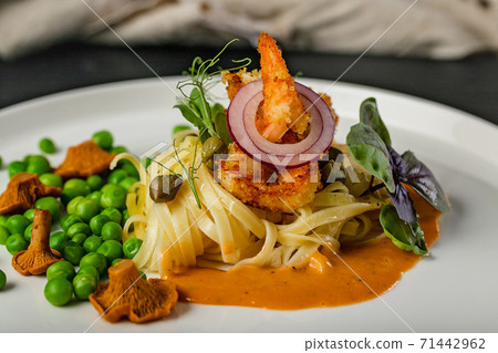 Close-up pasta and fried shrimps with green peas and original chanterelle sauce. Healthy and tasty food. Chef Original Recipe. 71442962