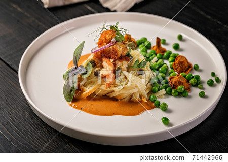 Pasta and fried shrimps with green peas and original chanterelle sauce. Healthy and tasty seafood. Signature dish. Pasta and fried shrimps with green peas and original chanterelle sauce. Healthy and tasty seafood. Signature dish. 71442966