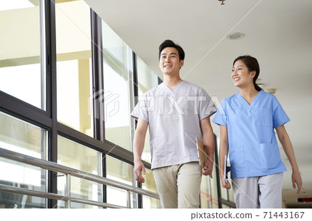 happy young asian physical therapists walking talking in hallway of nursing home happy young asian physical therapists walking talking in hallway of nursing home 71443167