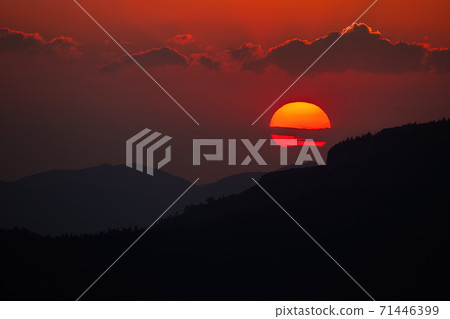 Cloudy sky with sun rising above dark horizon in summer nature Cloudy sky with sun rising above dark horizon in summer nature 71446399