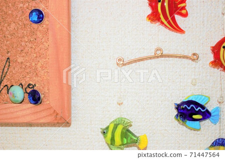 A fish object hung on the wall of the room and a thumbtack on a cork board A fish object hung on the wall of the room and a thumbtack on a cork board 71447564