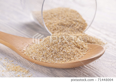 Oat bran in a wooden spoon and in a glass transparent glass on a white wooden table. The concept of a healthy breakfast for energy and mood all day Oat bran in a wooden spoon and in a glass transparent glass on a white wooden table. The concept of a healthy breakfast for energy and mood all day 71448004