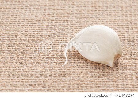 Garlic segment on wicker cloth made of natural materials, selective focus 71448274