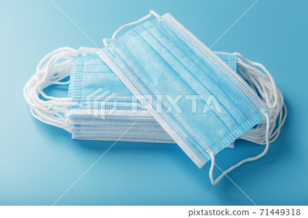 Stack of protective medical masks on a blue background, isolate. 71449318