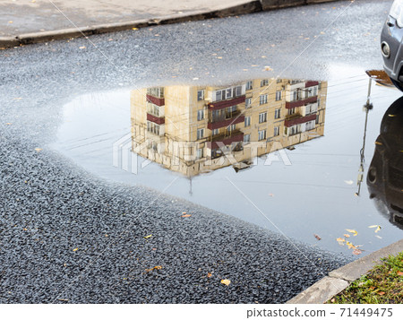 puddle with reflection of municipal urban house 71449475