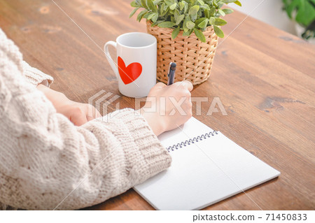 Young woman writing notes in a notebook 71450833