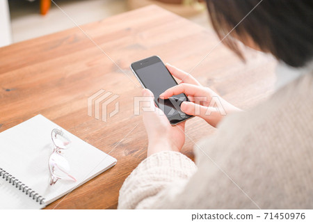 A young woman using a smartphone 71450976