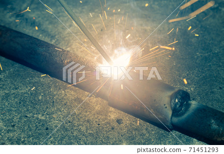 Welder Welding Car Part by Electrode Arc Welding Technique in Vintage Tone Welder Welding Car Part by Electrode Arc Welding Technique in Vintage Tone 71451293