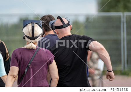 Unrecognizable people in VR goggles on street Unrecognizable people in VR goggles on street 71451388