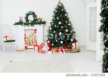 Christmas tree with gifts by the fireplace for the new year decor of the house Christmas tree with gifts by the fireplace for the new year decor of the house 71451391