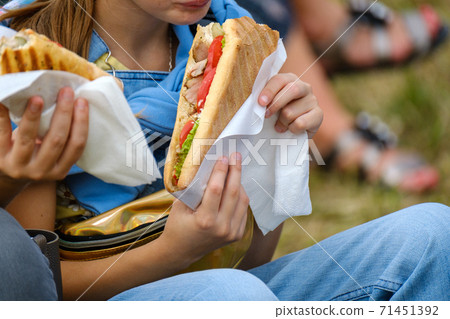 Crop girl eating sandwich in park Crop girl eating sandwich in park 71451392