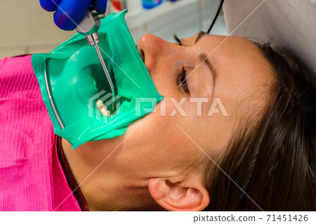 The dentist installs a rubber dam, sterile dental treatment, modern equipment in dentistry. The dentist installs a rubber dam, sterile dental treatment, modern equipment in dentistry. 71451426