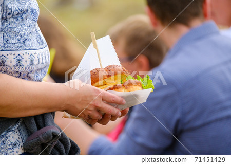 Crop person with delicious sandwich in crowd 71451429