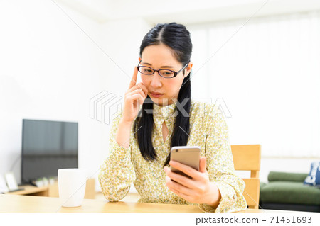 A woman using a smartphone A woman using a smartphone 71451693