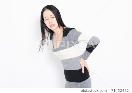 A woman putting her hands on her back A woman putting her hands on her back 71452422