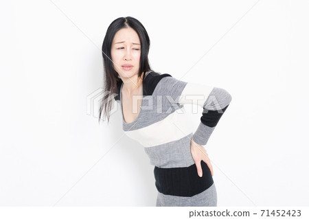 A woman putting her hands on her back A woman putting her hands on her back 71452423