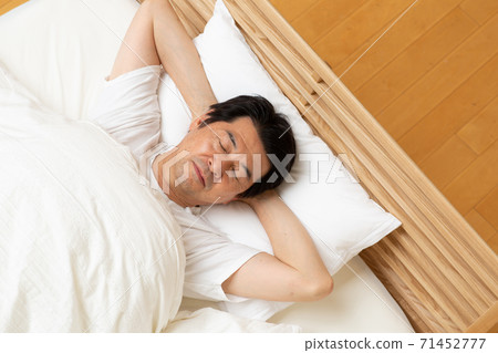 A man in his 60s sleeping in bed 71452777