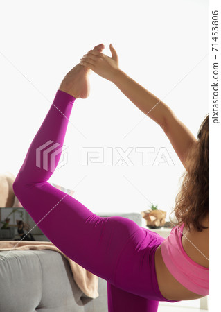 Close up young woman working out indoors, doing yoga exercise on gray mat at home Close up young woman working out indoors, doing yoga exercise on gray mat at home 71453806