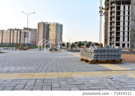 Installing paving bricks on patio at construction site.  71454511