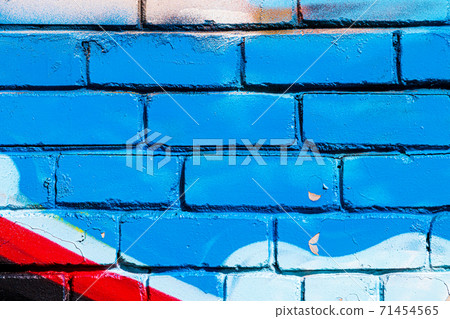 A fragment of colorful graffiti painted on a brick wall. Abstract backdrop for design. A fragment of colorful graffiti painted on a brick wall. Abstract backdrop for design. 71454565