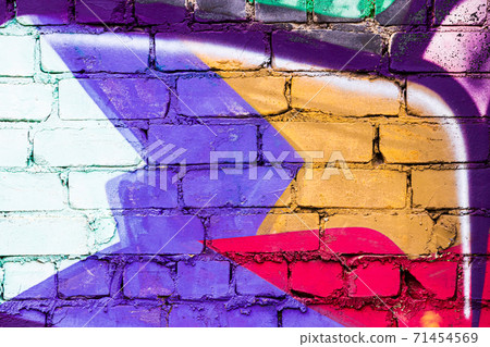 A fragment of colorful graffiti painted on a brick wall. Abstract backdrop for design. A fragment of colorful graffiti painted on a brick wall. Abstract backdrop for design. 71454569