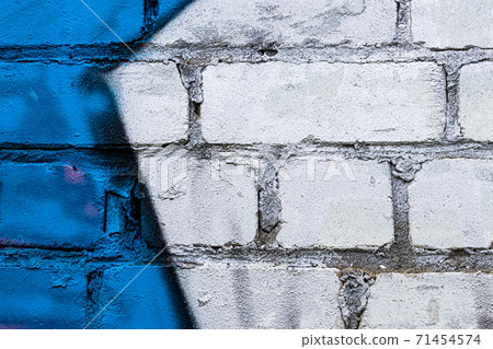 A fragment of colorful graffiti painted on a brick wall. Abstract backdrop for design. A fragment of colorful graffiti painted on a brick wall. Abstract backdrop for design. 71454574