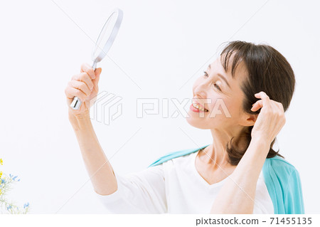 Woman checking hairstyle 71455135