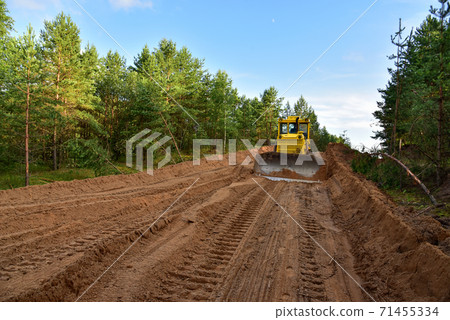 Dozer during clearing forest for construction new road .  71455334