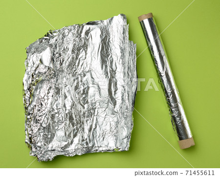 roll of gray foil for baking and packaging food on a green background roll of gray foil for baking and packaging food on a green background 71455611