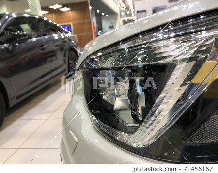 Headlight of a brand new car in the dealership, close-up shot Headlight of a brand new car in the dealership, close-up shot 71456167